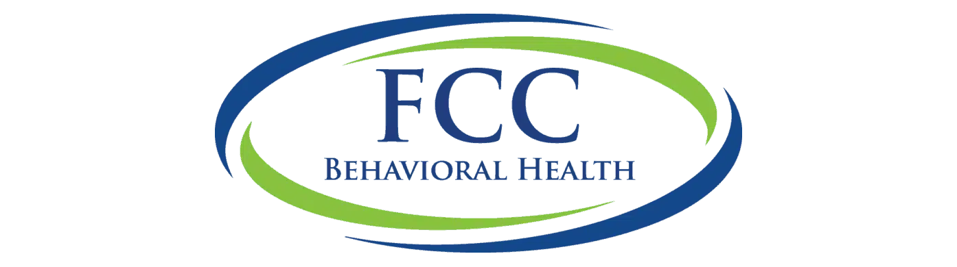 FCC International Coaches logo featuring blue “FCC” text above smaller blue “International Coaches” text, surrounded by two curved swooshes—one green on the upper left and one blue on the lower right.